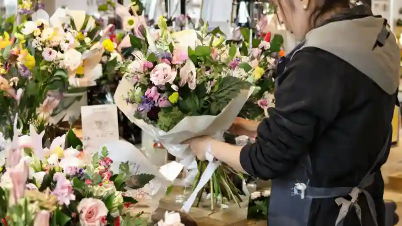 Флорист собирает букет в цветочном магазине